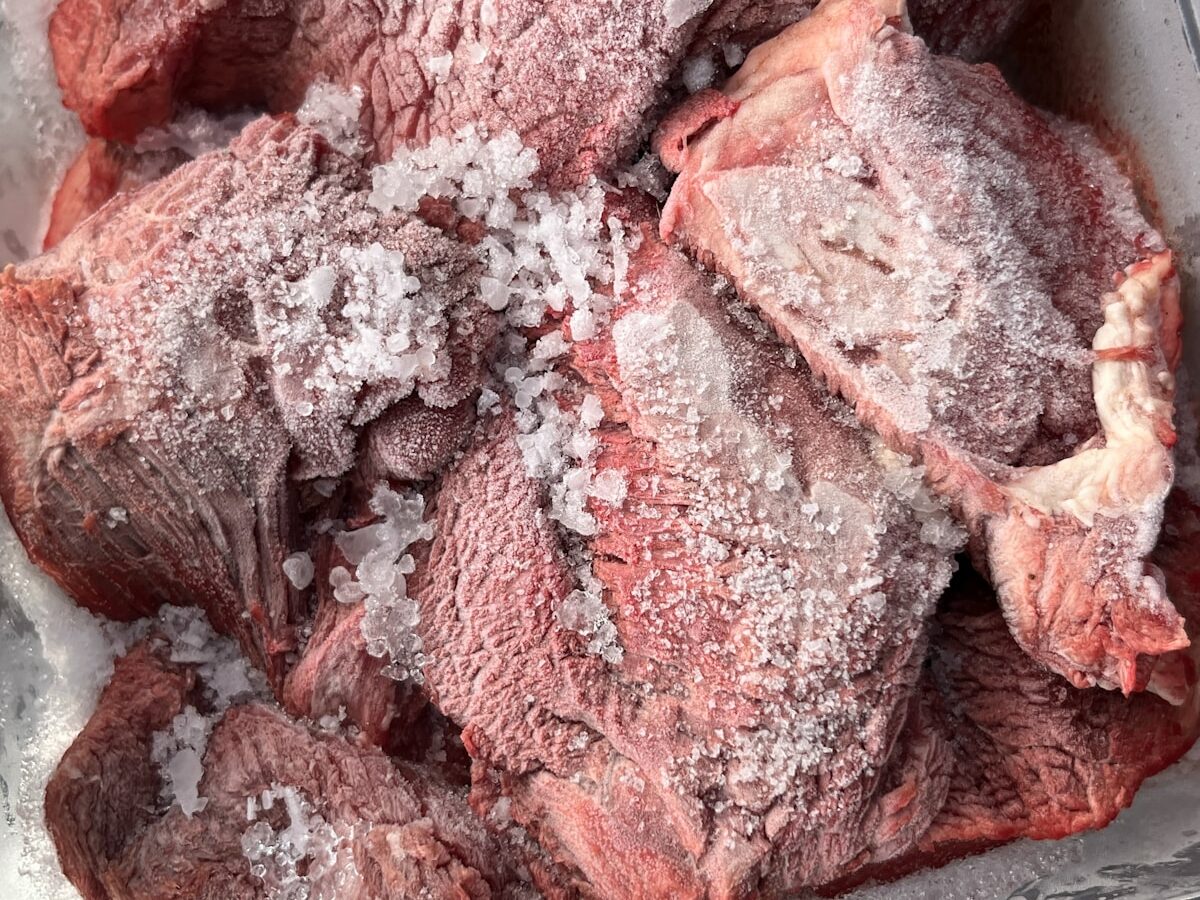 Raw frozen meat with ice crystals