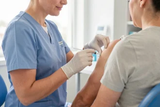 Infirmière préparant une vaccination sur le haut du bras d'un patient