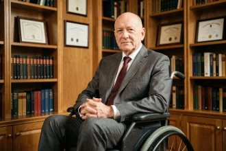 Homme distingué en fauteuil roulant dans une bibliothèque élégante, évoquant le personnage du professeur Xavier des X-Men